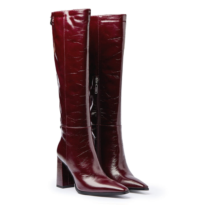Pair of cranberry knee-high boots on a white background